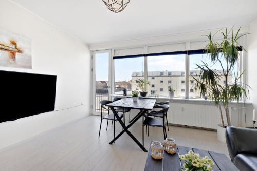 - un salon avec une table et une grande fenêtre dans l'établissement Moderne lejlighed med privat parkering, à Randers