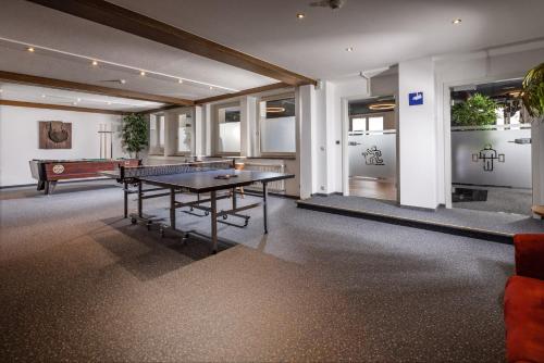 a room with a ping pong table and a pool table at Alm- & Wellnesshotel Alpenhof in Schönau am Königssee