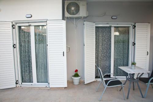 un patio con porte bianche, tavolo e sedie di Chris Luxury Studio a Ioannina
