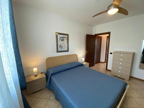 a bedroom with a blue bed and a ceiling fan at Melograno in Feriolo in Baveno
