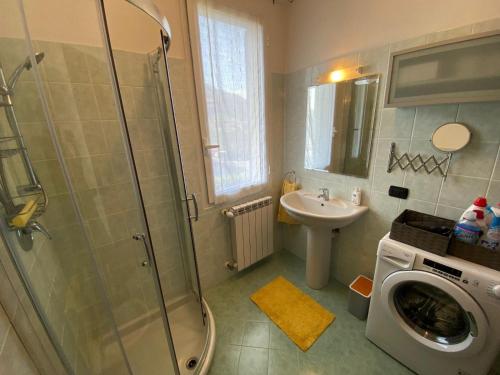 a bathroom with a shower and a sink and a washing machine at Melograno in Feriolo in Baveno