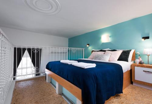 a bedroom with a large bed with blue walls at Agripas #4 in Jerusalem