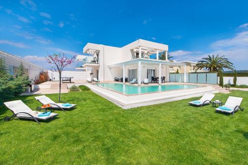 a villa with a swimming pool and lawn at Villa Myrto in Ialyssos