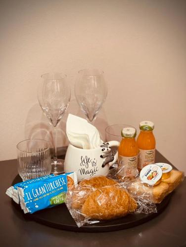 a table topped with wine glasses and croissants and bread at Donna Elena - Apartment in Asti