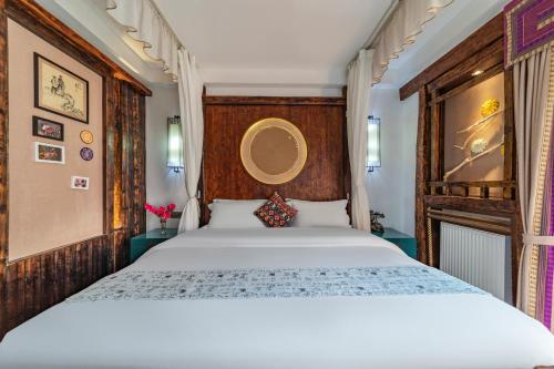 a bedroom with a white bed and a wooden headboard at Pandora Vista Retreat in Zhangjiajie