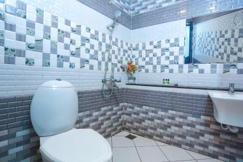 a bathroom with a white toilet and a sink at Double Decker Houseboat in Alleppey