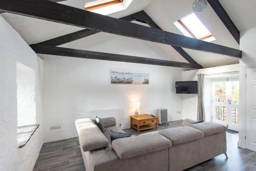 a living room with a couch and a tv at Tregenna Castle Resort in St Ives