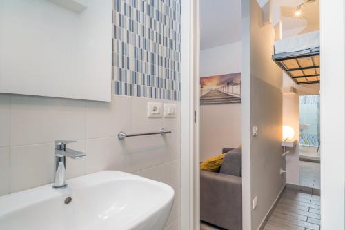 ein Bad mit einem Waschbecken und einem Sofa in einem Zimmer in der Unterkunft Monolocale Glicine in Schisò