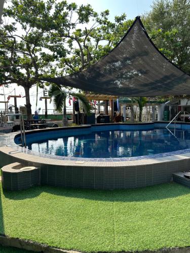 a large swimming pool with a tent over it at Generosa Beach Club in Bauang