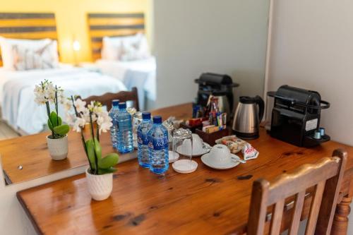 een houten tafel met flessen water en bloemen erop bij Faraway Lodge in Durban