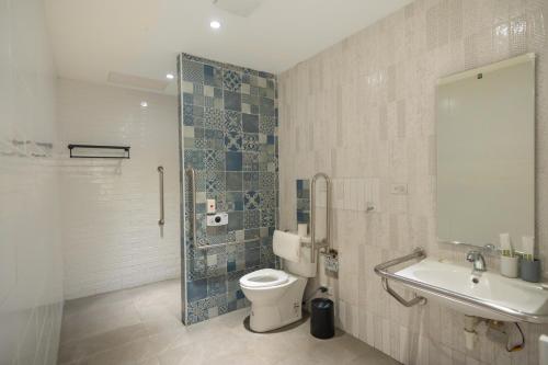 a bathroom with a toilet and a sink and a shower at The Way Inn in Taichung