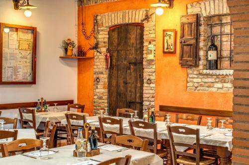 a restaurant with tables and chairs and a wooden door at Agriturismo Pozzo Fiorito in Castiglione delle Stiviere