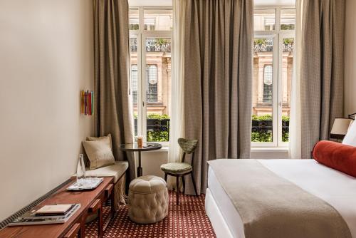 a hotel room with a bed and a desk at Château des Fleurs - Hôtel & Spa - Paris Champs-Elysées in Paris