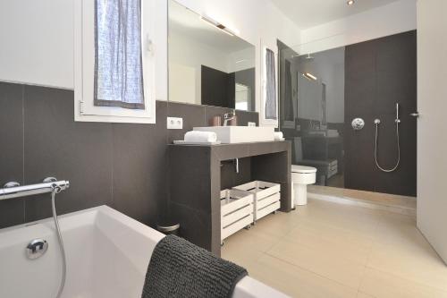 łazienka z białą wanną i umywalką w obiekcie Villa Carritx 4 pax w mieście Capdepera