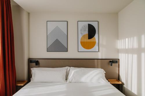 sypialnia z łóżkiem z trzema zdjęciami na ścianie w obiekcie Hotel Kramer w Walencji