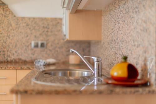- une cuisine avec un évier et un comptoir orange dans l'établissement Lurdes, à Ciutadella