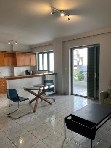 uma cozinha e sala de estar com mesa e cadeiras em Athens Riviera modern apartment em Piraeus