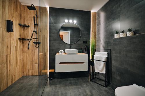 een badkamer met een wastafel en een spiegel bij ApartHome 25 by Housine in Zator