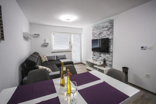 a living room with a table and a couch at Apartment Ma&Ja with Hot Tub in Metlika