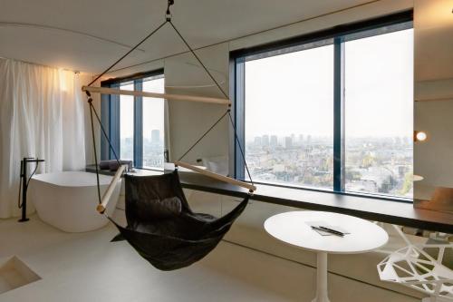a hammock hanging from a wall in a room with windows at Zonar Zagreb by Maistra City Vibes in Zagreb