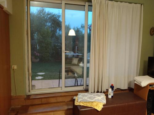 a room with a large window with a view of a yard at ησυχες διακοπες in Kalamata