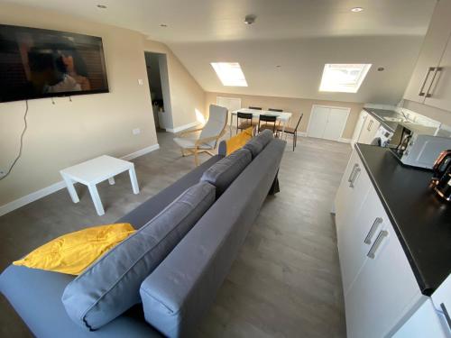 a living room with a blue couch and a table at STUNNING 1 BEDROOM FLAT IN WOOD GREEN in London