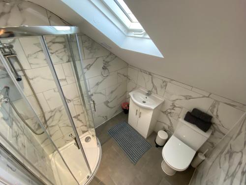 a bathroom with a glass shower and a toilet at STUNNING 1 BEDROOM FLAT IN WOOD GREEN in London