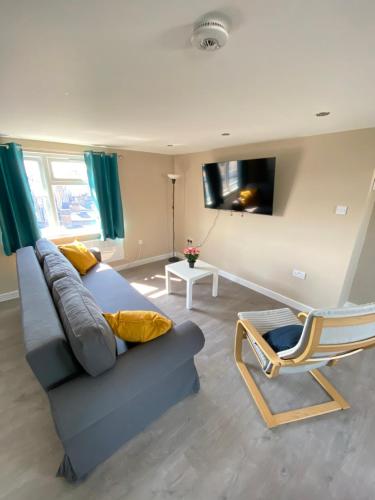 a living room with a couch and a chair at STUNNING 1 BEDROOM FLAT IN WOOD GREEN in London