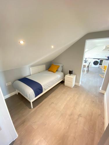 sypialnia z łóżkiem z żółtą poduszką w obiekcie STUNNING 1 BEDROOM FLAT IN WOOD GREEN w Londynie