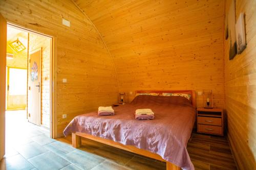 a bedroom with a bed in a wooden room at Imanje Lotus Garden in Šabac