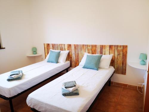 - 2 lits dans une chambre avec des serviettes dans l'établissement Casa Mea, à Porto Torres