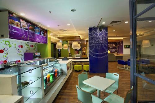 a restaurant with a counter and a table and chairs at Hotel Caspia Pro Greater Noida in Greater Noida