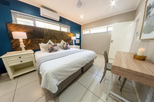 1 dormitorio con 1 cama grande y 1 mesa en Faraway Lodge, en Durban