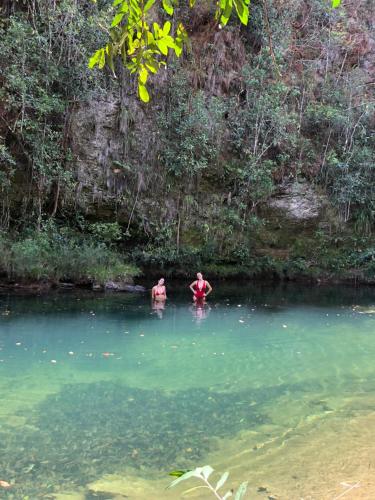 dwoje ludzi w wodzie w rzece w obiekcie Vila Floresta - Chalé Pato Mergulhão w mieście Alto Paraíso de Goiás