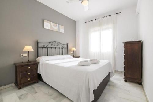 a bedroom with a large bed with two towels on it at La Alcazaba de Cristina in El Puerto de Santa María