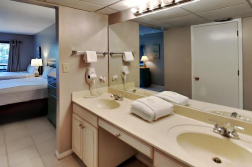 La salle de bains est pourvue d'un lavabo et d'un grand miroir. dans l'établissement Edgewater Villa 2203, à Panama City Beach