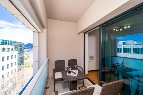 d'un balcon avec une table, des chaises et une grande fenêtre. dans l'établissement Apartment Dubrovnik Clouds, à Dubrovnik