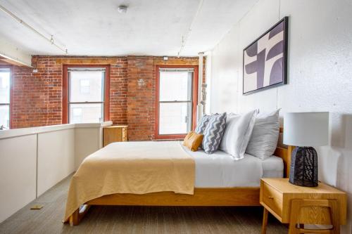 a bedroom with a bed and a brick wall at S End Loft w Pool Art Gallery Steps to T BOS-356 in Boston