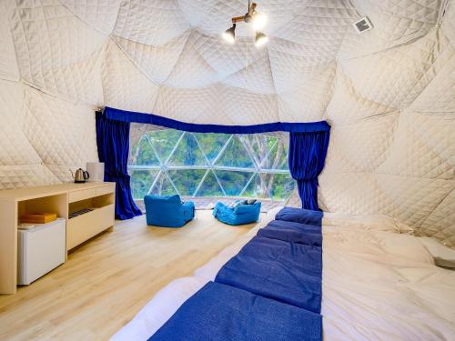 um quarto com uma cama e uma grande janela em Lupo Forest "GRAN FOREST Echizen Miyama" - Vacation STAY 07085v em Fukui