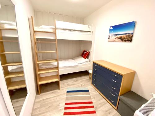 Cette petite chambre comprend des lits superposés et un bureau. dans l'établissement Achtern Diek, Whg 9, à Grömitz