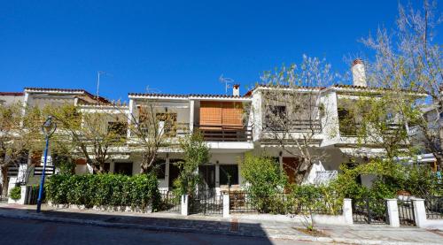 un gran edificio blanco con árboles delante de él en Avra Chanioti en Hanioti