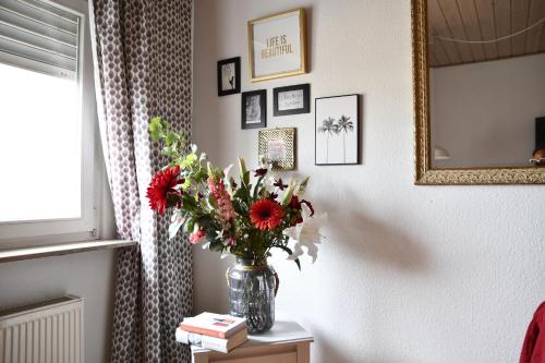 a vase of flowers on a table in a room at Double M Apartment in Seligenstadt