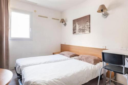 Un dormitorio con dos camas y un escritorio y una ventana. en Marseille Prado Perier, en Marsella
