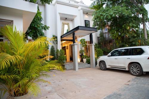 a white car parked in front of a house at Boutique Indochine d'Angkor in Siem Reap