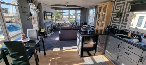 The Glen View في Port Seton: مطبخ وغرفة معيشة مع أريكة وطاولة