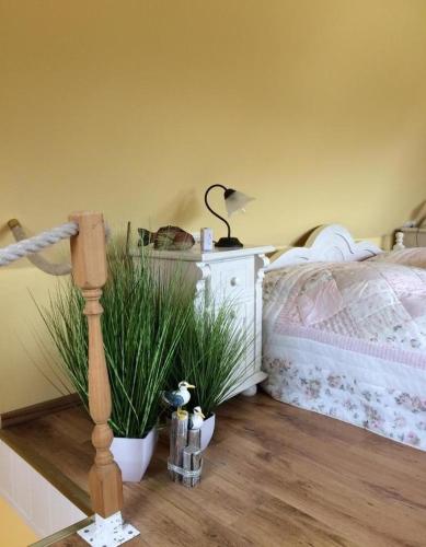 a bedroom with a bed and a table with plants at Ferienhaus Brise - Schmugglerhus in Wieck