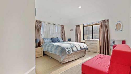 a bedroom with a bed and a window at La Maison Ocean - Mount Maunganui Holiday Home in Mount Maunganui