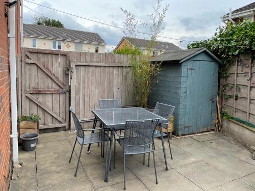 a table and chairs on a patio with a fence at Manchester 2 Bedroom House with Garden in Manchester