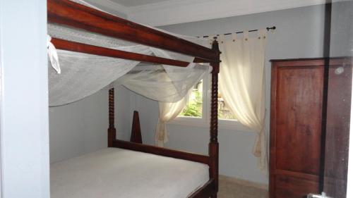 1 dormitorio con cama con dosel y ventana en ZEN Apartment, en Serres