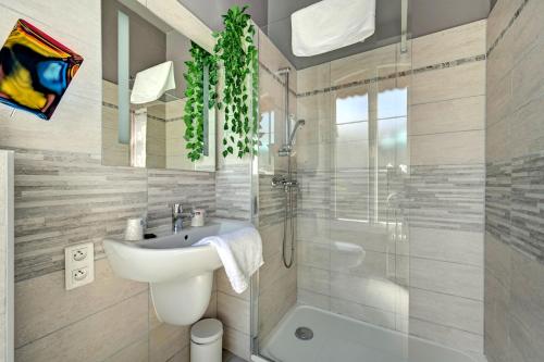 uma casa de banho com um lavatório, um WC e um chuveiro em Hotel Des Artistes em Tarascon